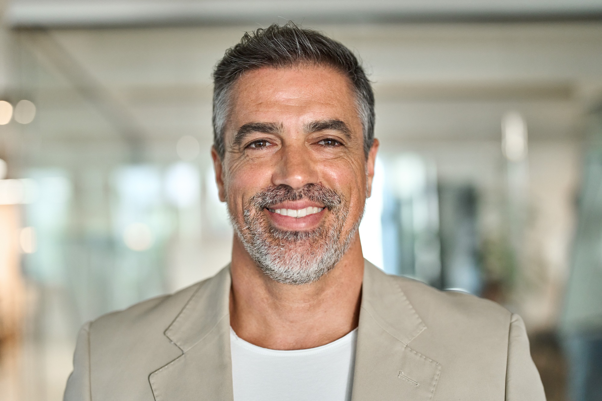 Happy middle aged business man standing in office. Headshot portrait